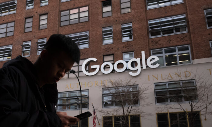 Um homem usando um telefone celular passa pelos escritórios do Google em Nova York em 17 de dezembro de 2018 (Mark Lennihan / AP Photo)
