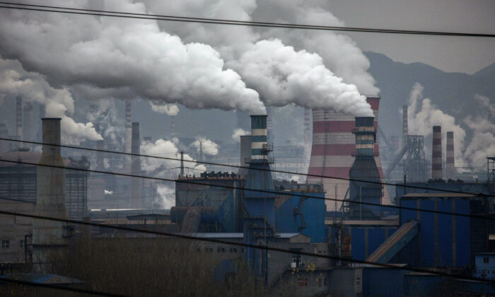 Ondas de fumaça saem de chaminés e um gerador a carvão em uma fábrica de aço na província de Hebei, no norte da China, em 19 de novembro de 2015 (Kevin Frayer / Getty Images)
