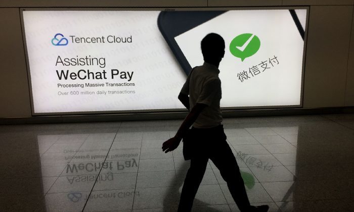 Um homem passa por um anúncio na rede social WeChat da Tencent no Aeroporto Internacional de Hong Kong em 21 de agosto de 2017 (RICHARD A. BROOKS / AFP / Getty Images)
