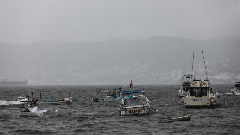 Pescadores protegem seus barcos nesta sexta-feira, 25 de junho de 2021, no calçadão de Acapulco, que está fechado para navegação devido à tempestade tropical Enrique, no estado de Guerrero (México). EFE / David Guzmán
