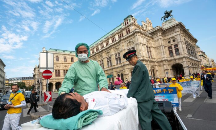 Praticantes do Falun Gong em Viena, Áustria, realizam uma demonstração de extração de órgãos contra praticantes presos na China, durante um protesto contra a importação de órgãos humanos da China para a Áustria em 1 de outubro de 2018 (JOE KLAMAR / AFP via Getty Images)
