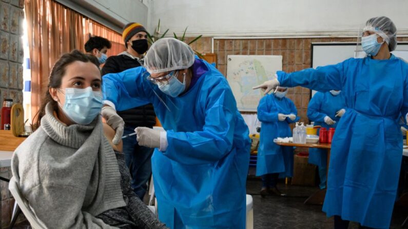 Uma mulher é inoculada com a primeira dose da vacina Pfizer-BioNTech covid-19 em Paso de Carrasco, departamento de Canelones, Uruguai, em 26 de maio de 2021 (Eitan Abramovich / AFP via Getty Images)
