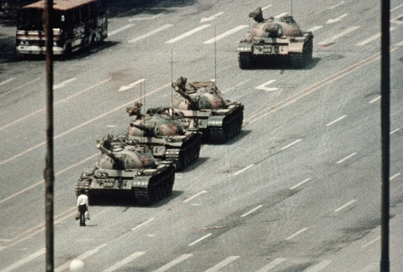 Um manifestante de Pequim bloqueia a passagem de um comboio de tanques ao longo da Avenida da Paz Eterna, perto da Praça Tiananmen. Durante semanas, as pessoas protestaram contra a liberdade de expressão e de imprensa do regime chinês (Getty Images / Bettmann)
