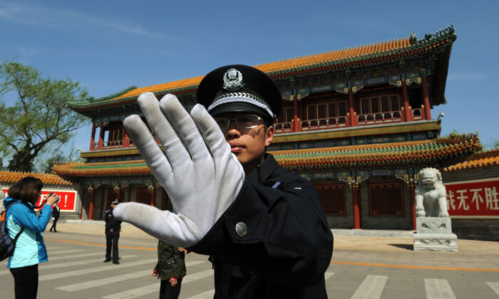 Nesta foto de arquivo, um policial impede que as fotos sejam tiradas do lado de fora de Zhongnanhai, a sede do regime comunista em Pequim (Mark Ralston / AFP / Getty Images)
