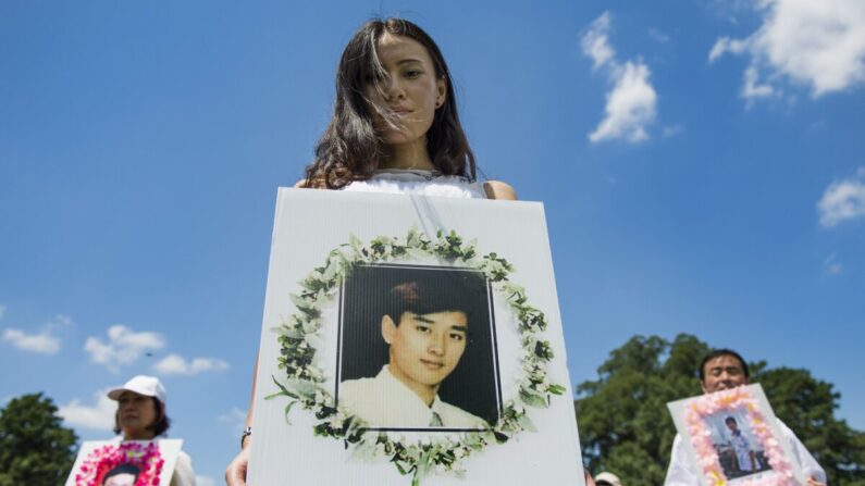 Os praticantes do Falun Gong seguram fotos comemorativas enquanto marchavam no Capitólio em Washington em 17 de julho de 2014 (Jim Watson / AFP via Getty Images)
 