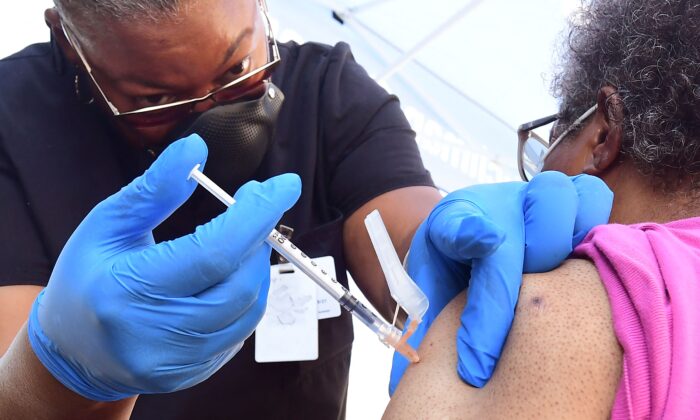 Uma enfermeira administra a vacina COVID da Pfizer a uma mulher em Los Angeles, Califórnia, em 16 de julho de 2021 (Frederic J. Brown / AFP via Getty Images)
