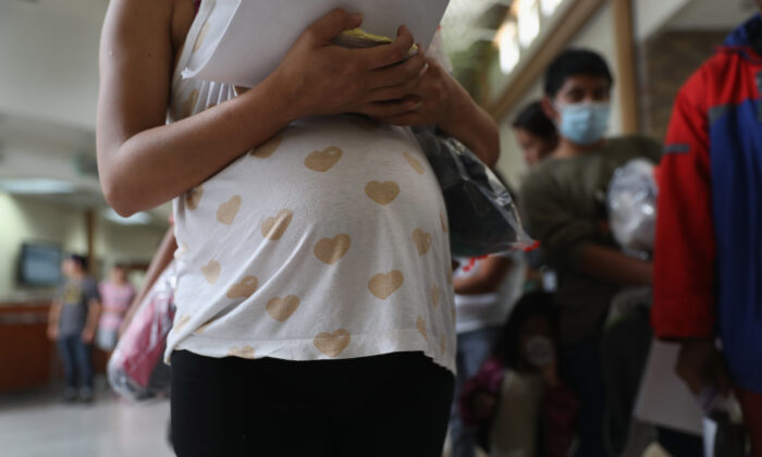 Uma imigrante hondurenha grávida faz fila com outros imigrantes para pegar um ônibus com destino aos Estados Unidos saindo de McAllen, Texas, em 15 de agosto de 2016 (John Moore / Getty Images)