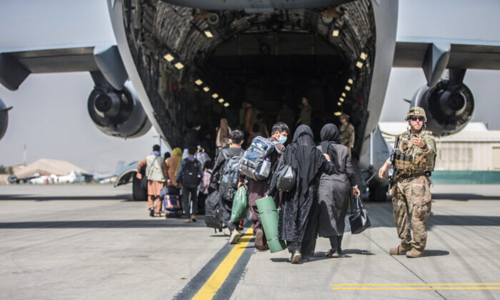 Famílias começam a embarcar em um avião de transporte C-17 Globemaster III da Força Aérea dos EUA durante uma evacuação no Aeroporto Internacional Hamid Karzai, Afeganistão, em 23 de agosto de 2021 (US Marine Corps / Sgt. Samuel Ruiz / Folheto via Reuters)
