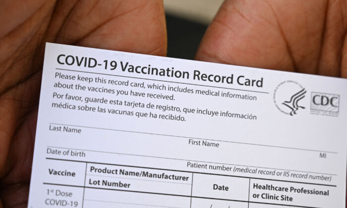 Um profissional de saúde exibe um cartão de registro de vacinação COVID-19 durante uma clínica de vacinação e saúde no QueensCare Health Center em um bairro predominantemente latino em Los Angeles, Califórnia, em 11 de agosto de 2021.(Robyn Beck / AFP via Getty Images)
