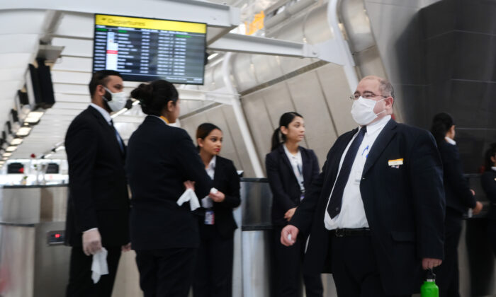 No terminal que atende aviões com destino à China, funcionários do aeroporto usam máscaras médicas no Aeroporto John F. Kennedy (JFK), preocupados com o romance Coronavírus na cidade de Nova Iorque em 31 de janeiro de 2020.(Spencer Platt / Getty Images)
