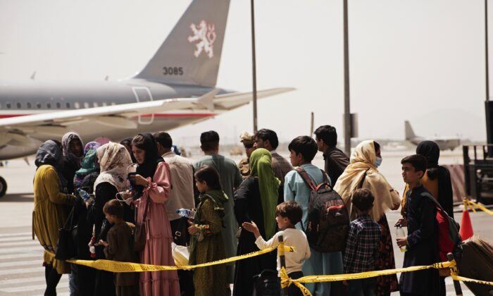 Civis se preparam para embarcar em um avião durante uma evacuação no Aeroporto Internacional Hamid Karzai, em Cabul, Afeganistão, em 18 de agosto de 2021. (Sargento Victor Mancilla / Corpo de Fuzileiros Navais dos EUA via AP)
