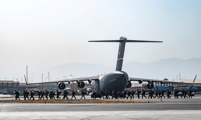 Soldados dos EUA, designados para a 82ª Divisão Aerotransportada, chegam para fornecer segurança em apoio à Operação Refúgio dos Aliados no Aeroporto Internacional Hamid Karzai em Cabul, Afeganistão, em 20 de agosto de 2021 (Aviador sênior Taylor Crul / Força Aérea dos EUA / Folheto via Reuters )
