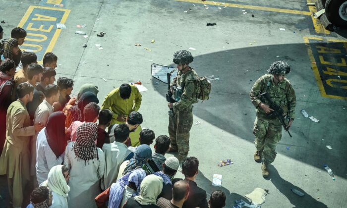 Soldados dos EUA montam guarda enquanto afegãos esperam no aeroporto de Cabul em Cabul, Afeganistão, em 16 de agosto de 2021 (Wakil Kohsar / AFP via Getty Images)
