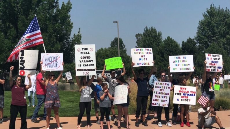 Várias pessoas se reúnem fora da UCHealth of the Rockies para protestar contra a decisão do sistema de saúde de demitir funcionários que recusam a vacina em Loveland, Colorado, em 13 de agosto de 2021 (Allan Stein / The Epoch Times)
