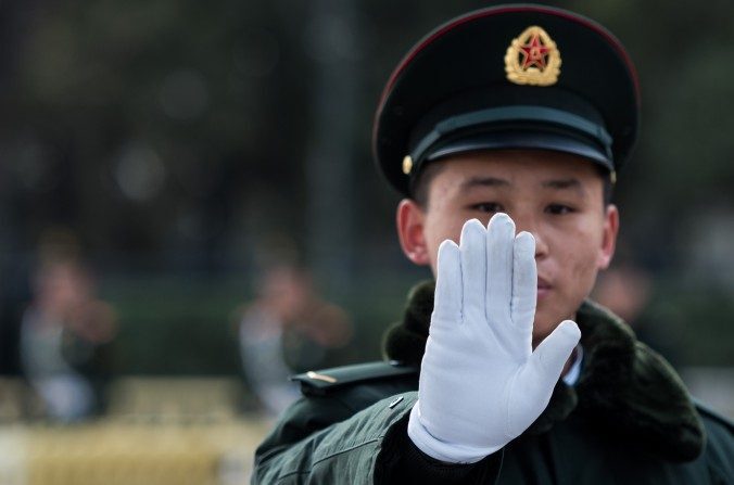 Um segurança gesticula do lado de fora do Grande Salão do Povo em Pequim no segundo dia do Congresso Nacional do Povo em 6 de março. O regime chinês anunciou recentemente sua Associação de Segurança Cibernética da China, que ajudará a impulsionar sua agenda para governar a Internet globalmente (Johannes Eisele / AFP / Getty Images)
