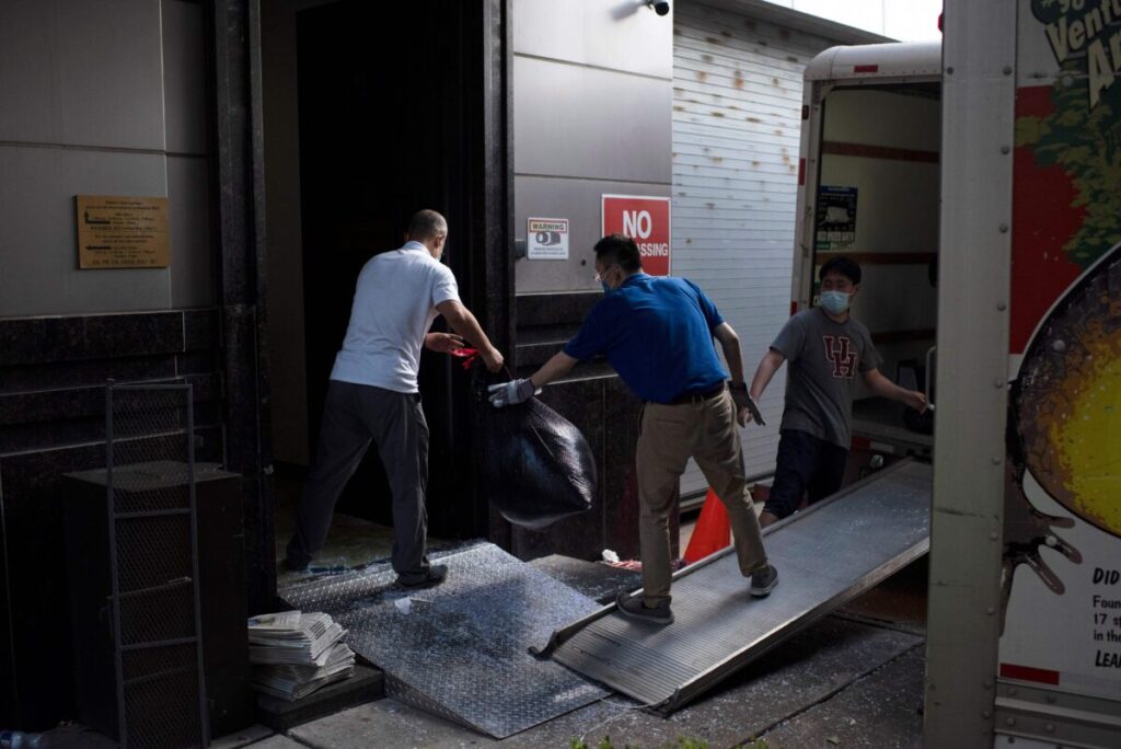 Pessoas transportam sacos de lixo do consulado chinês em Houston, Texas, em 24 de julho de 2020. O Departamento de Estado dos EUA ordenou que a China fechasse o consulado (Mark Felix / AFP via Getty Images)