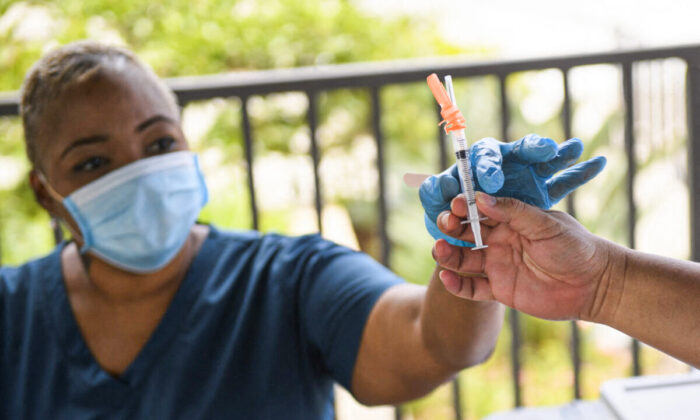Enfermeira recebe uma dose da vacina Pfizer contra a COVID-19 antes de administrá-la a um estudante universitário em uma clínica móvel de vacinação, no campus da California State University Long Beach na Califórnia, em 11 de agosto de 2021 (Patrick T. Fallon / AFP via Getty Images)
