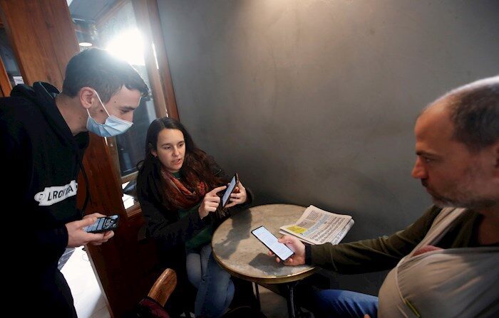 Casal mostra o certificado de vacinação ao responsável de um bar do bairro de Gracia, em Barcelona, ​​nesta sexta-feira, quando as infecções por coronavírus continuam crescendo na Catalunha (EFE / Marta Pérez)