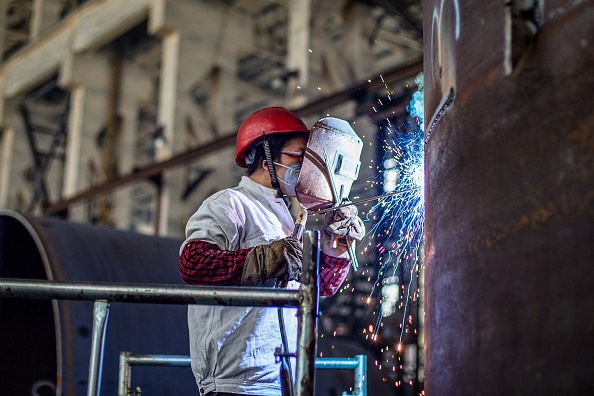 Trabalhador produz uma máquina de manufatura em uma fábrica em Nantong, na província de Jiangsu, no leste da China, em 26 de maio de 2021 (STR / AFP via Getty Images)
