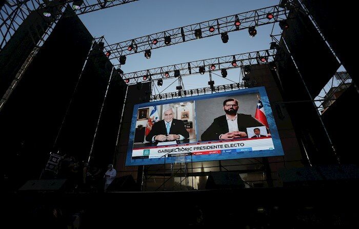 Em telas gigantes você poderá conferir a saudação do presidente Piñera (à esquerda) ao presidente eleito Gabriel Boric (à direita), em Santiago (Chile). O jovem deputado de esquerda Gabriel Boric, campeão da Frente Ampla e do Partido Comunista, conquistou a presidência do Chile no domingo ao obter 55,18% dos votos com 92% dos colégios eleitorais apurados (EFE / Elvis González)
