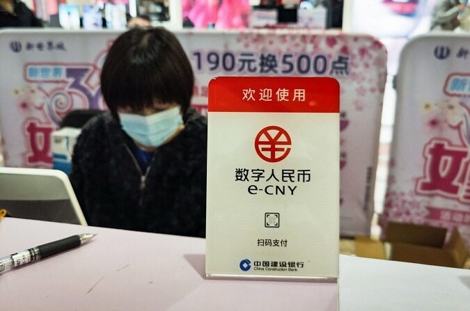 Pôster da nova moeda digital da China, o yuan chinês eletrônico (e-CNY), é exibido em um shopping center de Xangai, no dia 8 de março de 2021 (STR / AFP via Getty Images) 