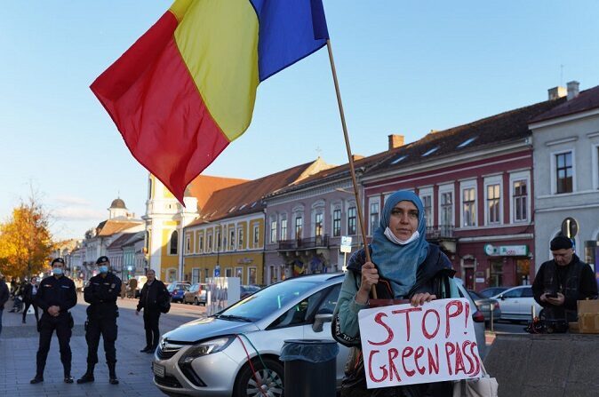 Mulher segura uma faixa que diz "Pare o Passe Verde" durante um protesto contra as restrições no dia 23 de outubro de 2021, em Cluj-Napoca, na Romênia (Andreea Campeanu / Getty Images) 
