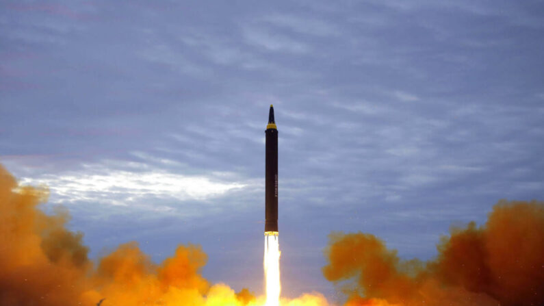 Foguete balístico estratégico de alcance intermediário Hwasong-12 da Coreia do Norte decolando da plataforma de lançamento em um local não revelado perto de Pyongyang (STR / AFP via Getty Images)
