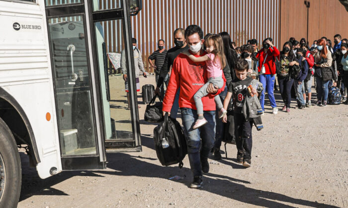 Imigrantes ilegais que se reuniram no muro da fronteira se preparam para embarcar em um ônibus que vai para a estação da Patrulha da Fronteira para processamento em Yuma, no Arizona, no dia 10 de dezembro de 2021 (Charlotte Cuthbertson/Epoch Times)