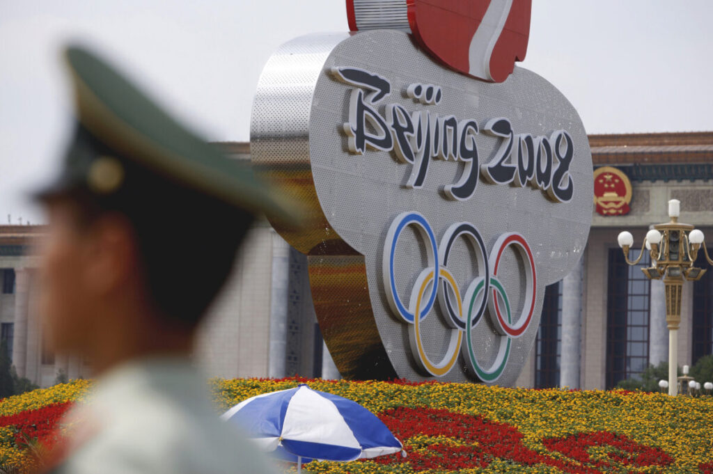 Policial passa por um logotipo das Olimpíadas de Pequim de 2008 (Ola Fagerstrom/Getty Images)