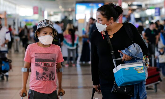 Passageiros caminham com máscaras protetoras no Aeroporto Internacional Arturo Merino Benitez, em Santiago, no Chile, no dia 3 de março de 2020 (Javier Torres/AFP via Getty Images)
