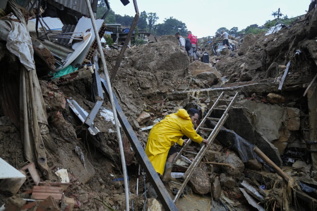 Equipes de resgate e moradores procuram vítimas em uma área afetada por deslizamentos de terra em Petrópolis, no Brasil, no dia 16 de fevereiro de 2022 (Silvia Izquierdo/AP Photo