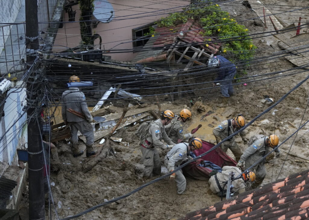 Equipes de resgate carregam o corpo de uma vítima de deslizamento de terra em Petrópolis, no Brasil, no dia 16 de fevereiro de 2022 (Silvia Izquierdo/AP Photo)