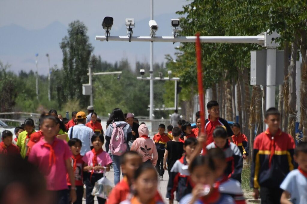 Crianças em idade escolar caminhando sob câmeras de vigilância em Akto, ao sul de Kashgar, na região ocidental de Xinjiang, na China, no dia 4 de junho de 2019 (Greg Baker/AFP via Getty Images)