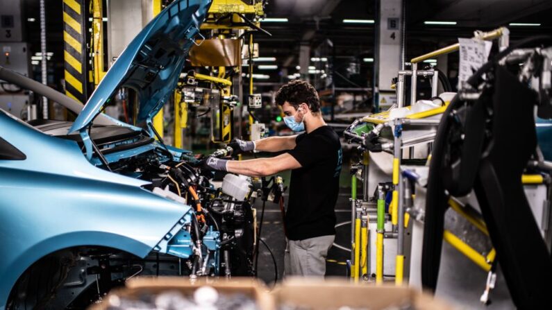 Funcionário trabalha na linha de montagem que produz o veículo elétrico Renault Zoe e o veículo híbrido Nissan Micra, em Flins-sur-Seine, o maior Renault local de produção na França em 6 de maio de 2020 (Foto de MARTIN BUREAU/AFP via Getty Images)