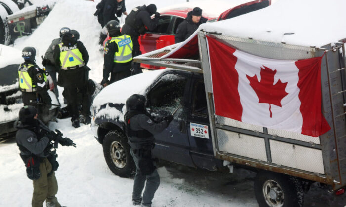 Um policial quebra uma janela de caminhão enquanto a polícia se mobiliza para remover manifestantes em Ottawa, no dia 19 de fevereiro de 2022 (Dave Chan/AFP via Getty Images)