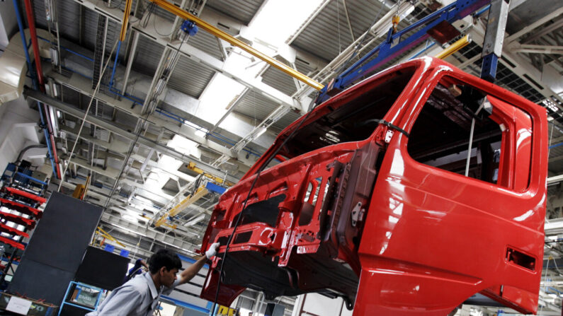 Funcionário indiano da fabricante sueca de caminhões e ônibus Volvo trabalha na linha de montagem da fábrica da Volvo em Hoskote, cerca de 40 km ao sul de Bangalore, em 10 de abril de 2006. A Volvo começou a desenvolver a Índia como um centro de fornecimento de serviços de engenharia para apoiar os expansão na Ásia, e atualmente a Volvo Índia exporta ônibus para Bangladesh e caminhões para a Coreia do Sul (DIBYANGSHU SARKAR/AFP via Getty Images)