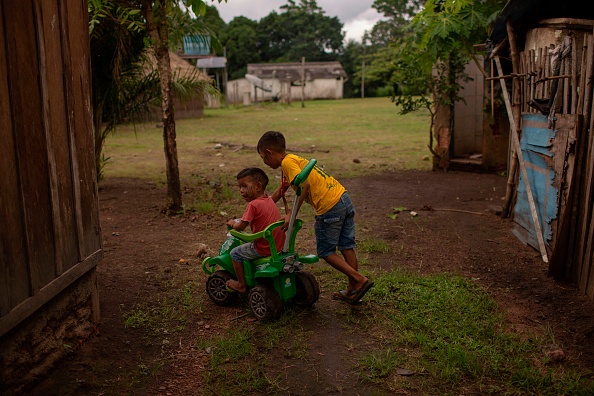 Foto de arquivo de crianças indígenas brincando entre casas, na floresta amazônica, no norte do Brasil, em 15 de março de 2019 (MAURO PIMENTEL/AFP via Getty Images)
