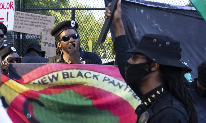 Manifestantes carregam uma faixa do Novo Partido dos Panteras Negras durante um protesto na Praça Lafayette, perto da Casa Branca, em Washington, no dia 7 de junho de 2020 (Jose Luis Magana/AFP via Getty Images)
