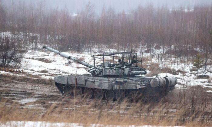 Um tanque se move ao longo de um campo durante exercícios conjuntos das forças armadas da Rússia e da Bielorrússia perto de Minsk em 17 de fevereiro de 2022 (Maxim Guchek/BELTA/AFP via Getty Images)