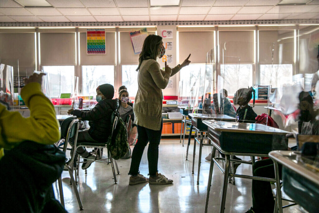 Um grupo de crianças aprende com uma professora da Stark Elementary School em Stamford, em Connecticut, no dia 10 de março de 2021 (John Moore/Getty Images)