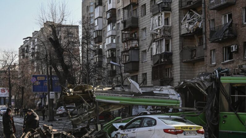 Um militar ucraniano (E) caminha em frente a um prédio de apartamentos destruídos após bombardeio, em Kiev, na Ucrânia, no dia 14 de março de 2022 (Aris Messinis/AFP via Getty Images)