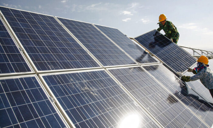 Trabalhadores instalam painéis solares em uma usina fotovoltaica em Hami, na Região Autônoma Uigur de Xinjiang, no noroeste da China, no dia 22 de agosto de 2011 (Chinatopix via AP)