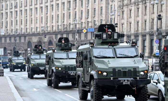 Veículos militares ucranianos passam pela Praça da Independência no centro de Kiev no dia 24 de fevereiro de 2022. Sirenes de ataque aéreo soaram no centro de Kiev hoje, quando cidades em toda a Ucrânia foram atingidas pelo que autoridades ucranianas afirmaram ser ataques de mísseis e da artilharia russa (Daniel Leal/AFP via Getty Images)
