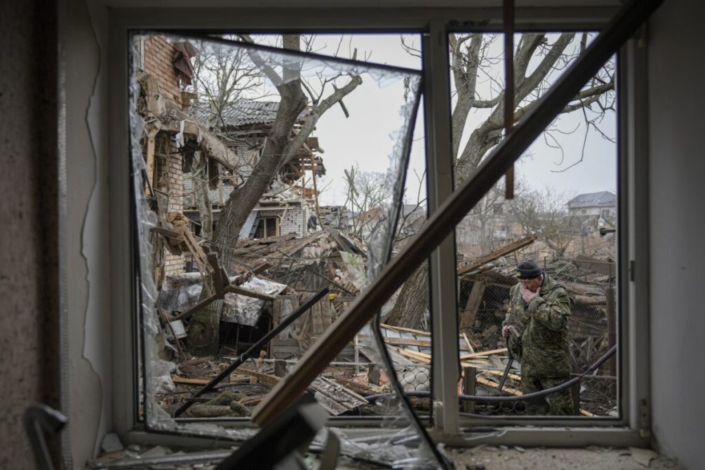 Andrey Goncharuk, de 68 anos, membro da defesa territorial, limpa o rosto no quintal de uma casa que foi danificada por um ataque aéreo russo, segundo moradores, em Gorenka, nos arredores da capital Kiev, na Ucrânia, no dia 2 de março de 2022 (Vadim Ghirda/ AP Photo)