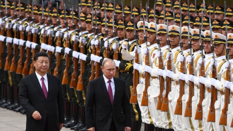 O líder da Rússia, Vladimir Putin (C), analisa uma guarda de honra militar com o líder chinês Xi Jinping durante uma cerimônia de boas -vindas do lado de fora do grande salão do povo em Pequim, 8 de junho de 2018 (foto de Greg Baker/Pool/AFP via Getty Images)