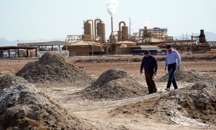 Rod Colwell, CEO da Controlled Thermal Resources (D), e Tracy Sizemore, diretora global de materiais para baterias da empresa, caminham por potes de lama geotérmica perto da costa do Salton Sea, onde a empresa está minerando lítio, em Niland, Califórnia. , em 15 de julho de 2021 (Marcio Jose Sanchez/AP Photo)