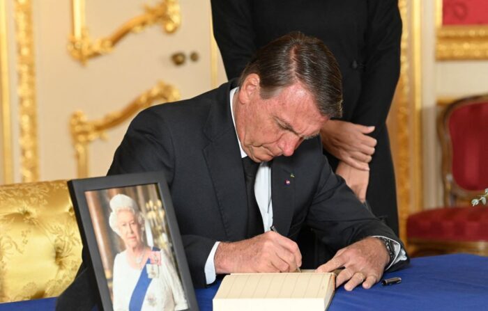 O presidente brasileiro Jair Bolsonaro assina um livro de condolências na Lancaster House, em Londres, em 18 de setembro de 2022, após a morte da rainha Elizabeth II em 8 de setembro. para receber líderes mundiais e enquanto os enlutados faziam fila nas últimas 24 horas restantes para ver seu caixão, que jazia no Westminster Hall no Palácio de Westminster. (Foto de Jonathan HORDLE / POOL / AFP (Foto de JONATHAN HORDLE/POOL/AFP via Getty Images)