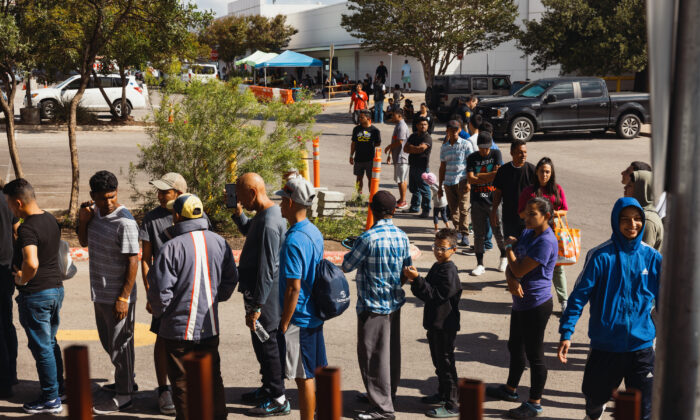 Grupos de imigrantes ilegais em busca de asilo esperam do lado de fora do Migrant Resource Center para receber comida da San Antonio Catholic Charities em San Antonio, Texas, em 19 de setembro de 2022 (Jordan Vonderhaar/Getty Images)
