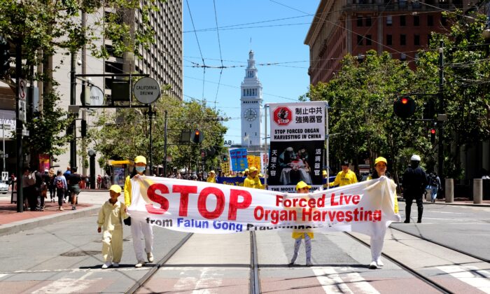 Adeptos do Falun Gong seguram uma faixa exigindo o fim da extração involuntária de órgãos durante um desfile em São Francisco em 16 de julho de 2022 (David Lam/The Epoch Times)
