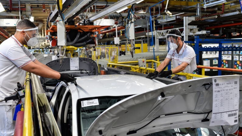 Funcionários usando máscaras de proteção trabalham na montagem de um carro na fábrica da Fiat Chrysler Automobiles em 10 de junho de 2020 em Betim, Brasil (Foto de Pedro Vilela/Getty Images)